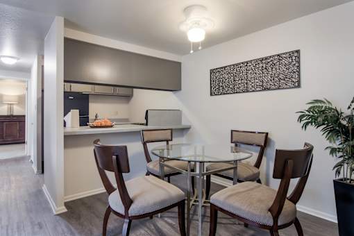 A dining room with a glass table and chairs.
