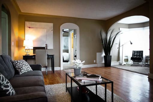 Living room with arched ceiling design and wood floors.