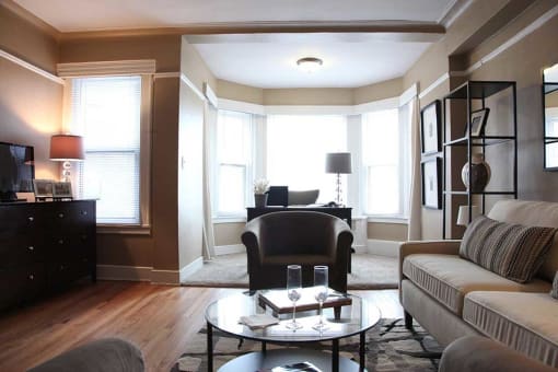 Furnished living room with wood floors and reading nook.