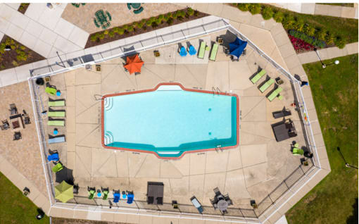 An aerial view of a swimming pool surrounded by lounge chairs and umbrellas.