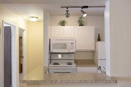 A kitchen with a stove, microwave, and oven.