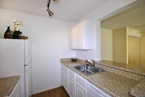 A kitchen with a sink and a refrigerator.