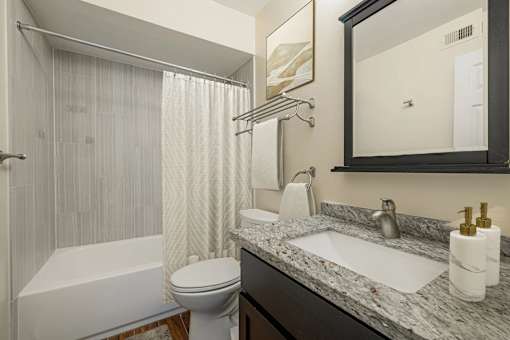 A bathroom with a white tub, sink, and toilet.