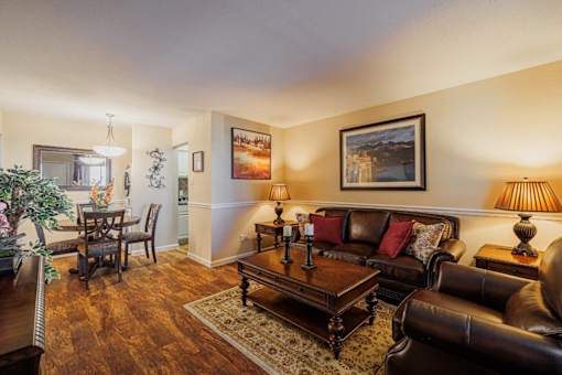 A living room with a brown leather couch and a wooden coffee table.