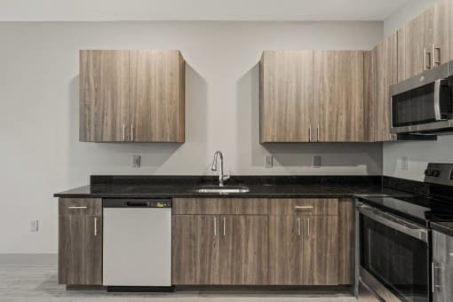 a kitchen with wooden cabinets and a black counter top