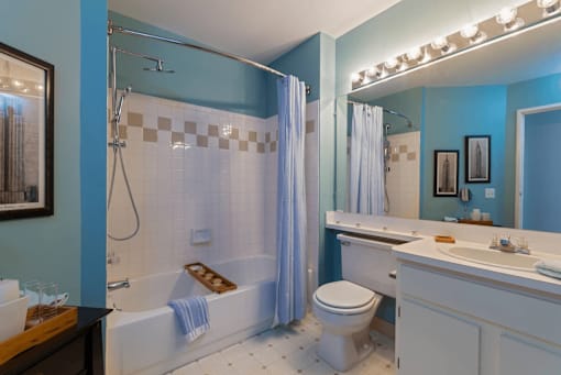 A blue bathroom with a white toilet and a white sink.