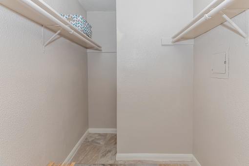 A white wall with a shelf and a small square hole.