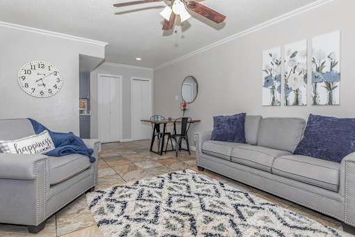 A living room with a grey couch, a round table, and a rug.