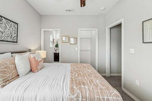 A bedroom with a large bed and a ceiling fan.