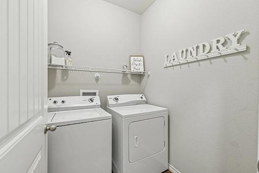 A laundry sign is on the wall above a washer and dryer.