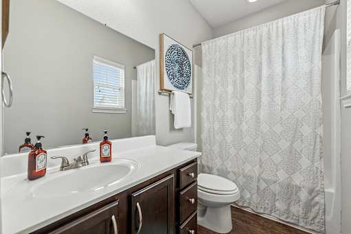 A bathroom with a white sink and a white toilet.