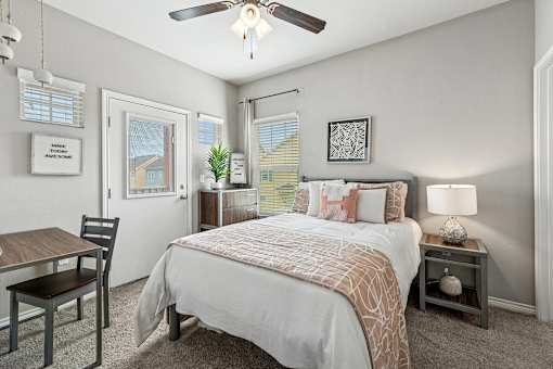 A bedroom with a bed, nightstand, and chair.
