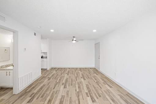 A room with wooden flooring and white walls.