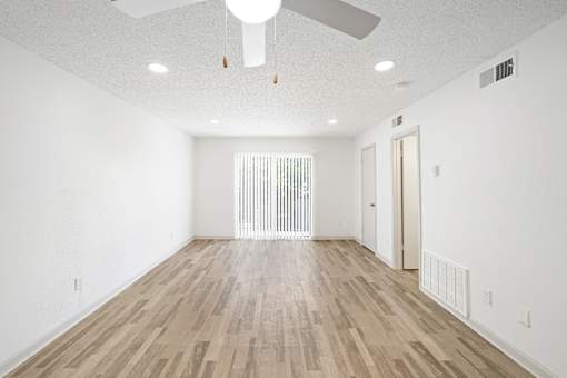 A room with wooden flooring and a ceiling fan.