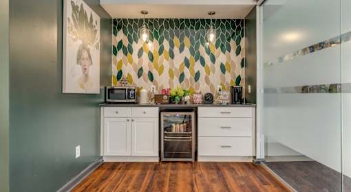 A kitchen with a green wall and a white cabinet.