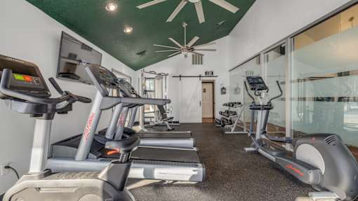 A gym with treadmills and elliptical machines.