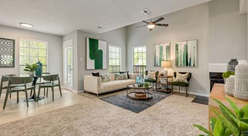 A living room with a couch, chairs, and a rug.