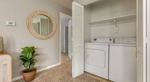 A small room with a washer and dryer stacked on top of each other.