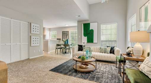A living room with a white couch and a green cushion.