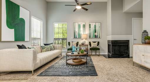 A living room with a white couch, a coffee table, and a fireplace.