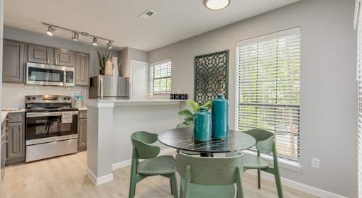 A kitchen with a table and chairs.