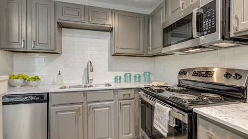 A kitchen with a stove, oven, and microwave.