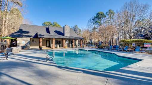 A large swimming pool in front of a house.