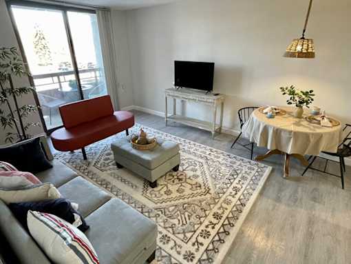 A living room with a red chair, a white table, and a television.