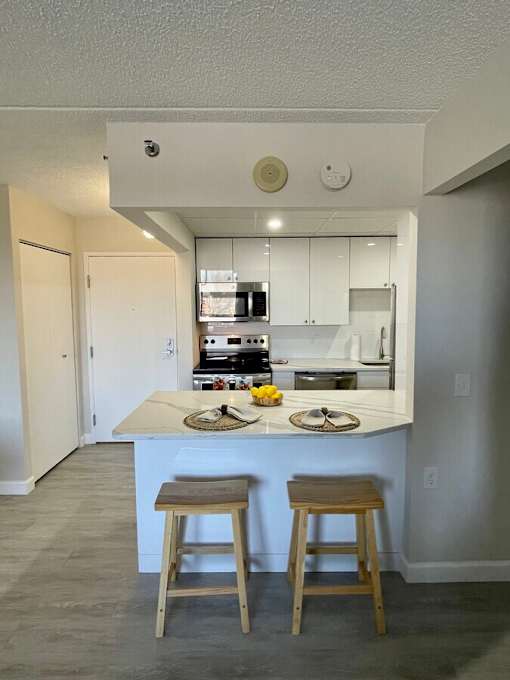A kitchen with a counter and two stools.