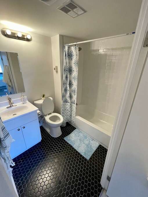 A bathroom with a toilet, sink, and shower.