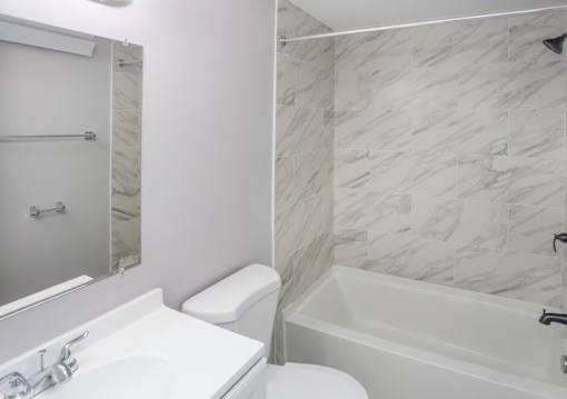 A white toilet sits next to a sink in a bathroom.