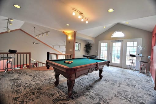 a game room with a pool table in the middle at Village Club on Franklin, Southfield Michigan
