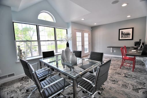 a dining room with a glass table and chairs at Village Club on Franklin, Southfield, 48034