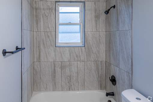 A bathroom with a tub, toilet, and sink.