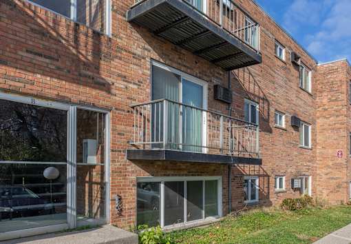 A red brick building with a balcony and a fire escape.