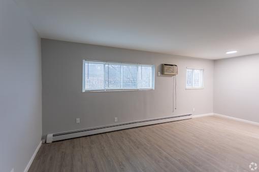 A room with a window and a wall-mounted air conditioner unit.