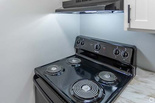 A black stove top with four burners and knobs.