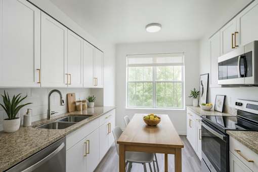 A kitchen with white cabinets and a granite countertop.