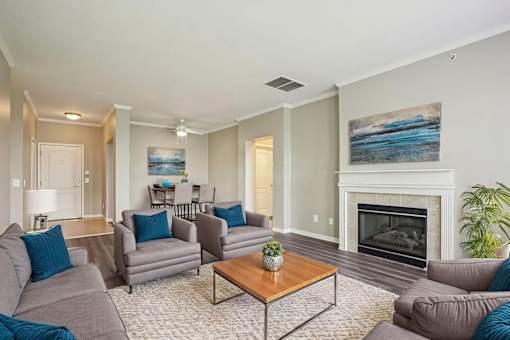 A living room with a fireplace and a painting on the wall.