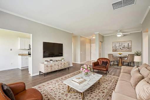 A living room with a patterned rug and a coffee table in the center.