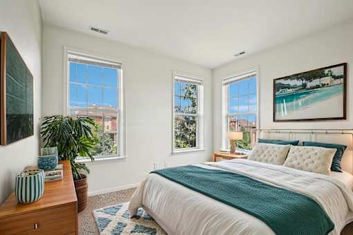 A bedroom with a large bed and a painting on the wall.