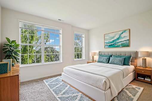 A bedroom with a large bed and a painting on the wall.