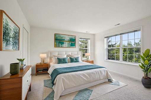 A bedroom with a large bed and a painting on the wall.