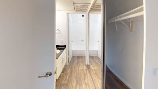 A white door is open to a kitchen and a hallway.