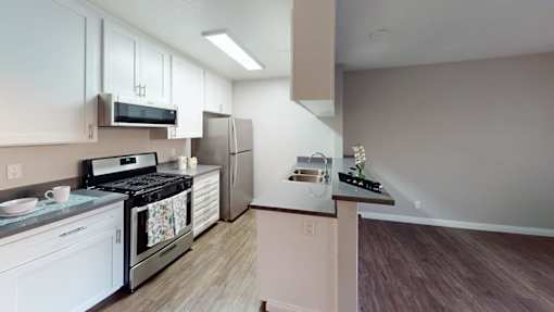 A kitchen with white cabinets and a stove top oven.