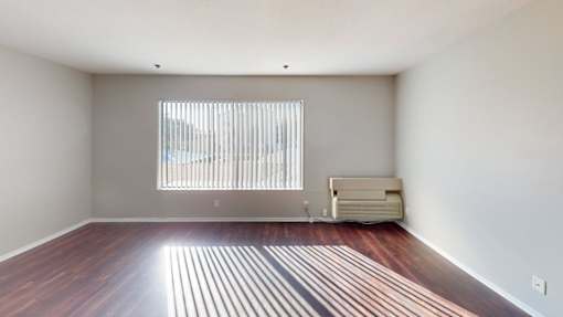 A room with a window and a sofa.
