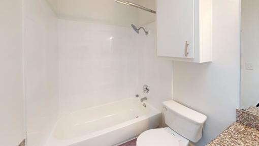 A white bathroom with a toilet, sink, and bathtub.
