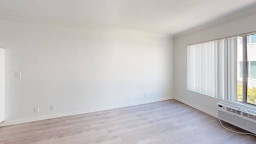 A room with a window and a radiator on the floor.