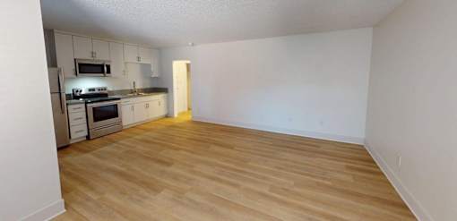 A kitchen with a stove top oven and a refrigerator.