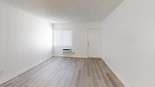 A room with a white door and a window with blinds.
